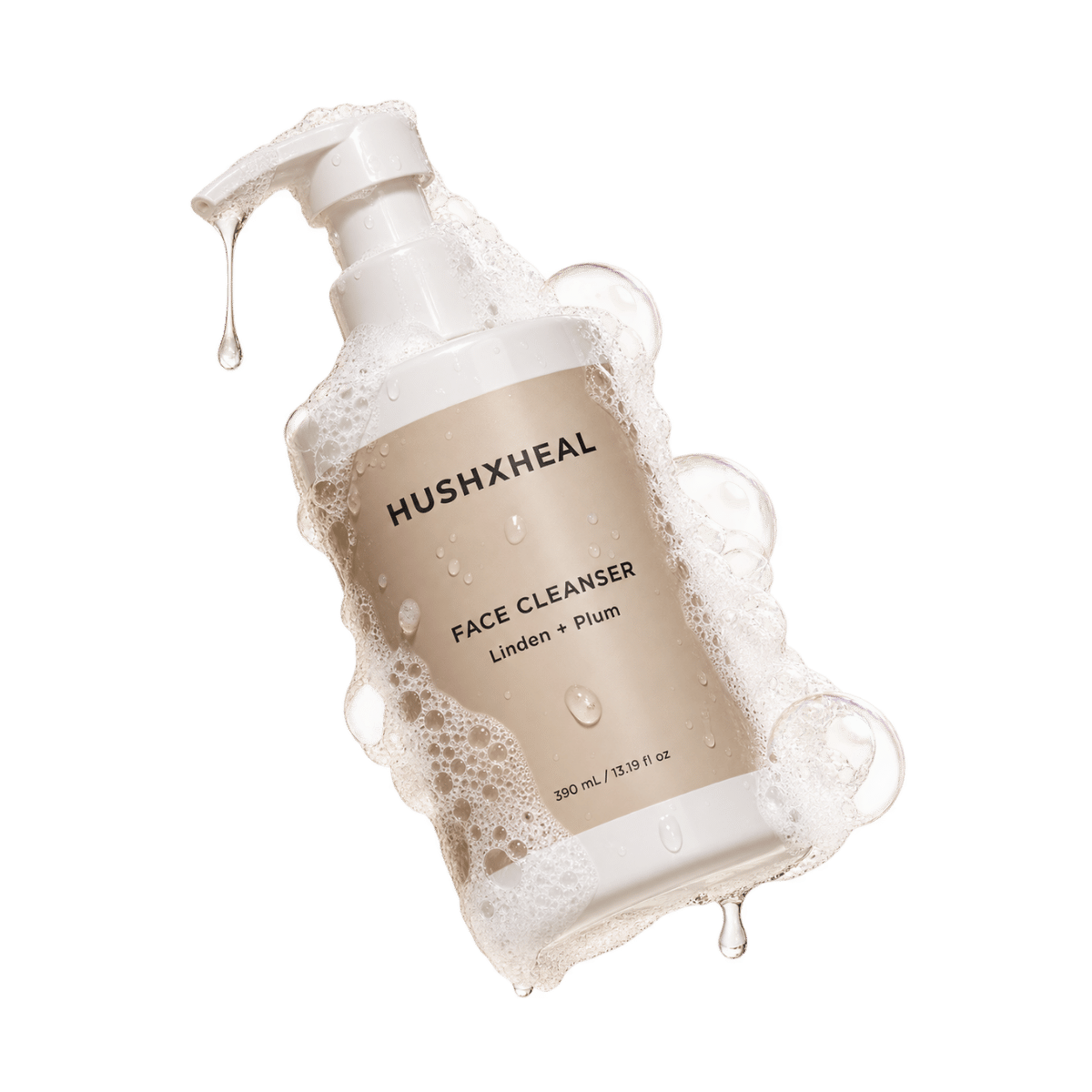 HUSHXHEAL Linden + Plum Face Cleanser 390 mL in a white pump bottle with a beige label, surrounded by cleansing foam, bubbles and water droplets.