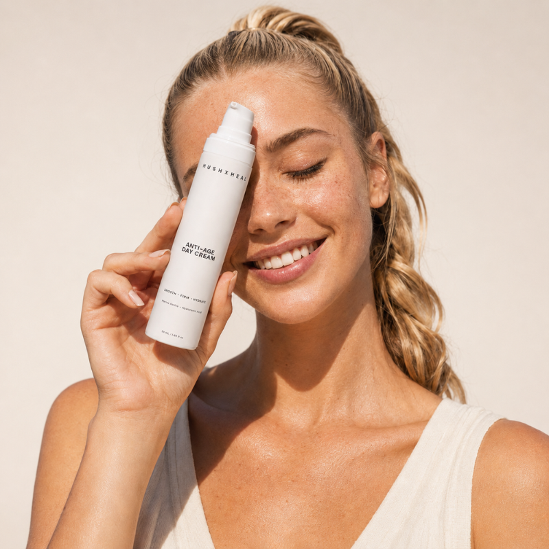 Nava holding HUSHXHEAL Anti-Age Day Cream against a soft background that matches the product’s clean neutral tone.