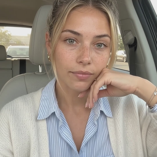 A young blonde woman inside a car holds and discusses HUSHXHEAL Linden + Plum Face Cleanser in a natural, daylight-lit skincare video.