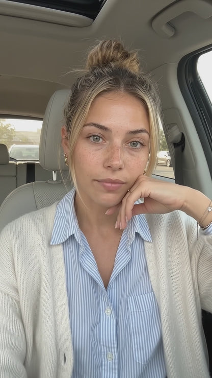 A young blonde woman inside a car holds and discusses HUSHXHEAL Linden + Plum Face Cleanser in a natural, daylight-lit skincare video.